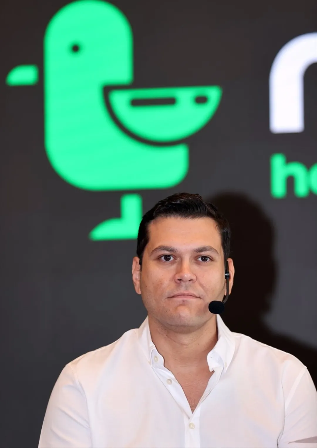 Martı kurucusu ve CEO'su Oğuz Alper Öktem marka logosunun önünde konuşurken
